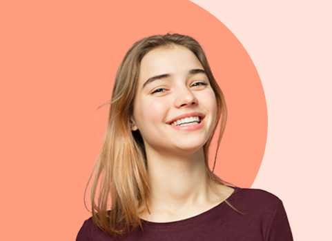 high school aged girl smiling on orange background.