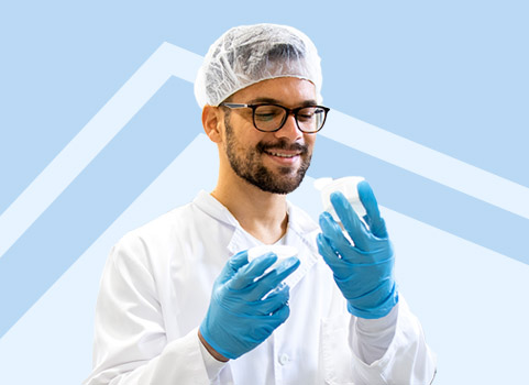 Sterile processing technician in PPE on blue background.