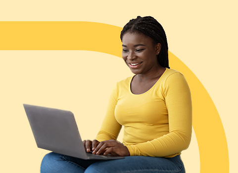 Girl in yellow long sleeve shirt and jeans using laptop. 