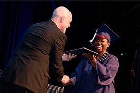 Woman receving her diploma during graduation.