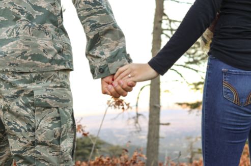 Service member and partner holding hands