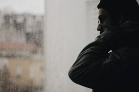 man looking out window