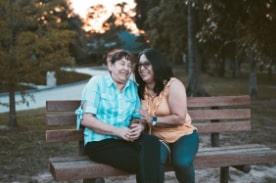 two women sitting on a park bench.