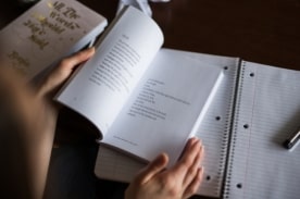 person studying & taking notes.