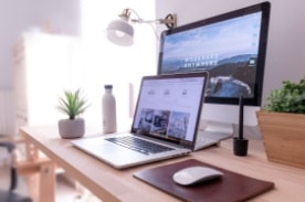 laptop in front of monitor on desk