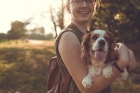 girl holding dog outside.