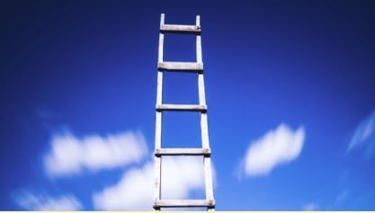 simple wooden ladder against blue sky with clouds