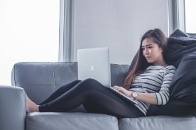 woman using apple computer on couch.