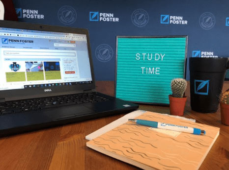 Open laptop, notebook, and pen.