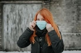 woman putting on face mask.