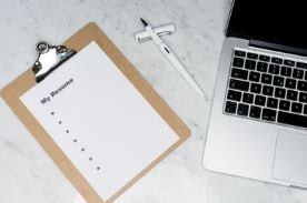 computer and clip board on table.