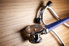 stethoscope on wooden table.