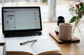 Notebook open in front of laptop.