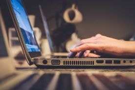 person using a laptop on desk.