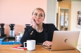 Woman looking bored sitting at computer.