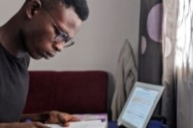 man studying with computer and book.