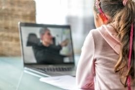 Back of girl looking at laptop screen.