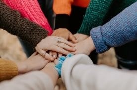 Hands gathered in a circle stacked on top of each other.