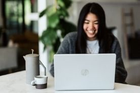 Smiling girl at laptop.