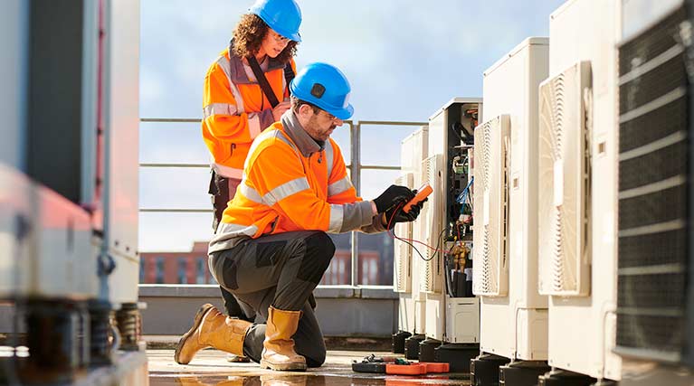 HVAC technicians performing work on rooftop units.