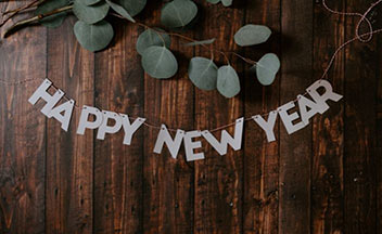 Paper Happy New Year sign on wooden background.