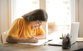 woman writing in notebook.