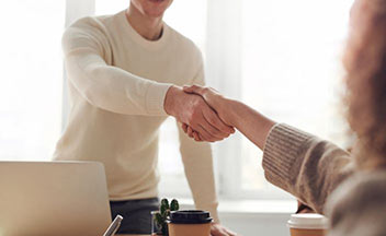 man shaking woman's hand for job interview.