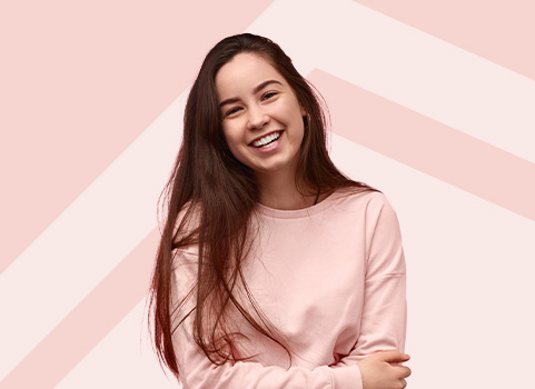 Girl in pink sweater smiling.