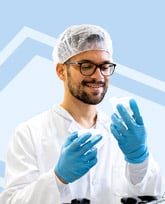 Sterile processing technician in PPE on blue background.