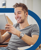 Man in grey t-shirt holding tablet.