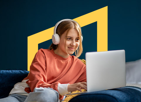 Teenage girl in orange sweater wearing headphones and using laptop.