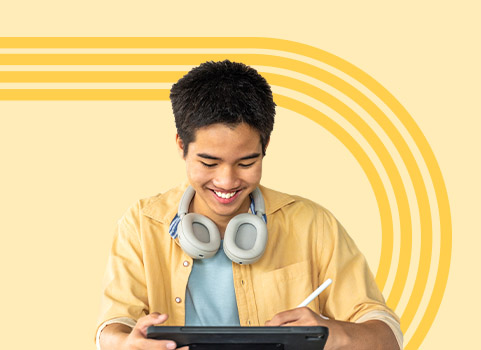 Teen boy in yellow shirt using tablet.