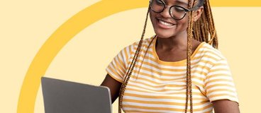 girl in yellow striped tshirt using silver laptop on orange background.