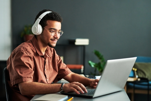man with headphones on laptop.