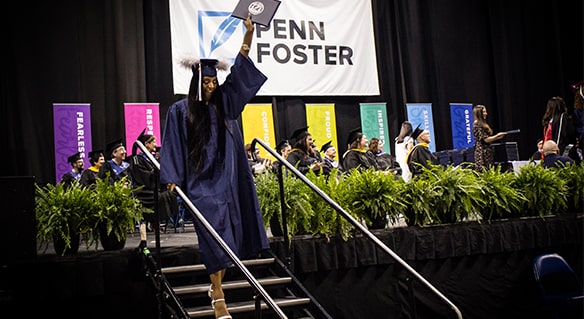 student on the Penn Foster graduation stage with her diploma.