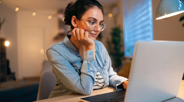 woman with glasses on laptop.