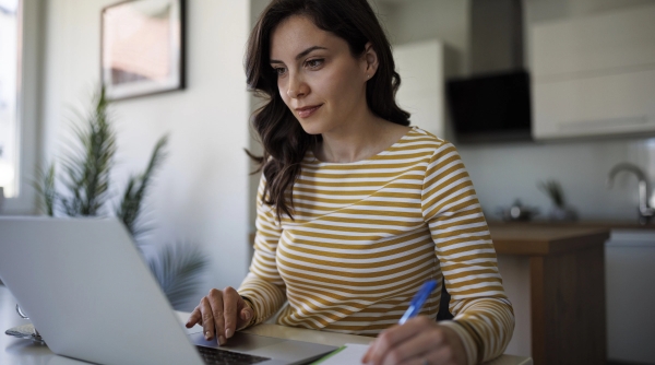 Woman in striped shirt taking notes.