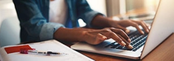hands typing on a laptop keyboard.