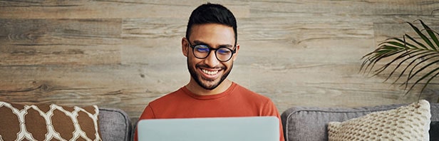 man smiling working on laptop.