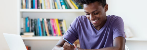 student at desk with a laptop.