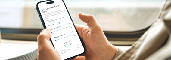 Person holding smartphone displaying tuition calculator for Penn Foster.