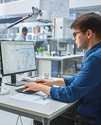 AutoCAD® drafter working on a computer.