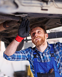 automotive transmission technician under vehicle.