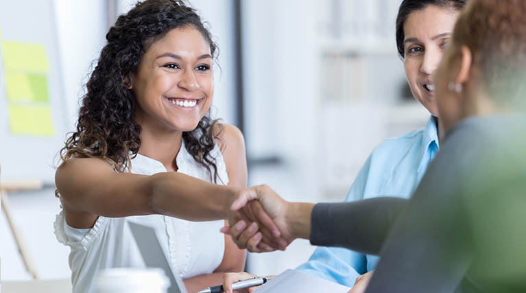 professional woman shaking hands in meeting.