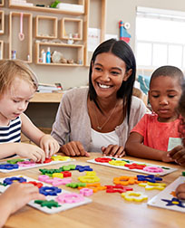 early childhood educator sitting with students.