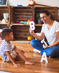 early childhood educator teaching student the alphabet.