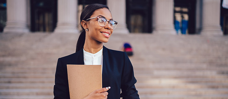 female criminal justice professional in front of courthouse.