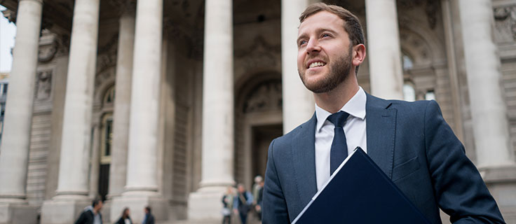male criminal justice professional in front of courthouse.
