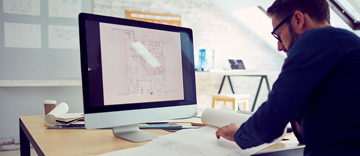 person drafting with AutoCAD® at desk.