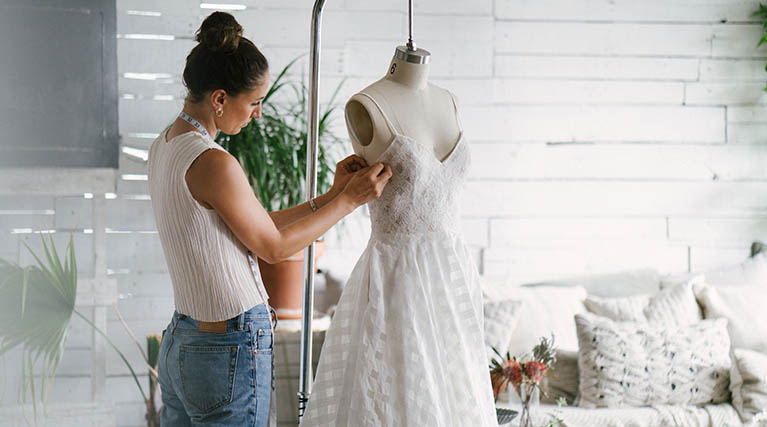 dressmaker altering a wedding dress.